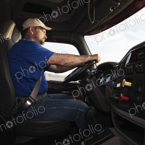 Caucasian man driver in the cab of a commercial truck. Caucasian man driver in the cab of a commercial truck.