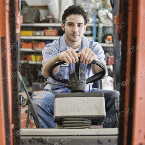 Caucasian man employee driving a forklift for a landscape company. Caucasian man employee driving a forklift for a landscape company.