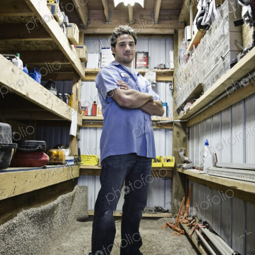 Caucasian man employee standing in the parts department of a landscape company.