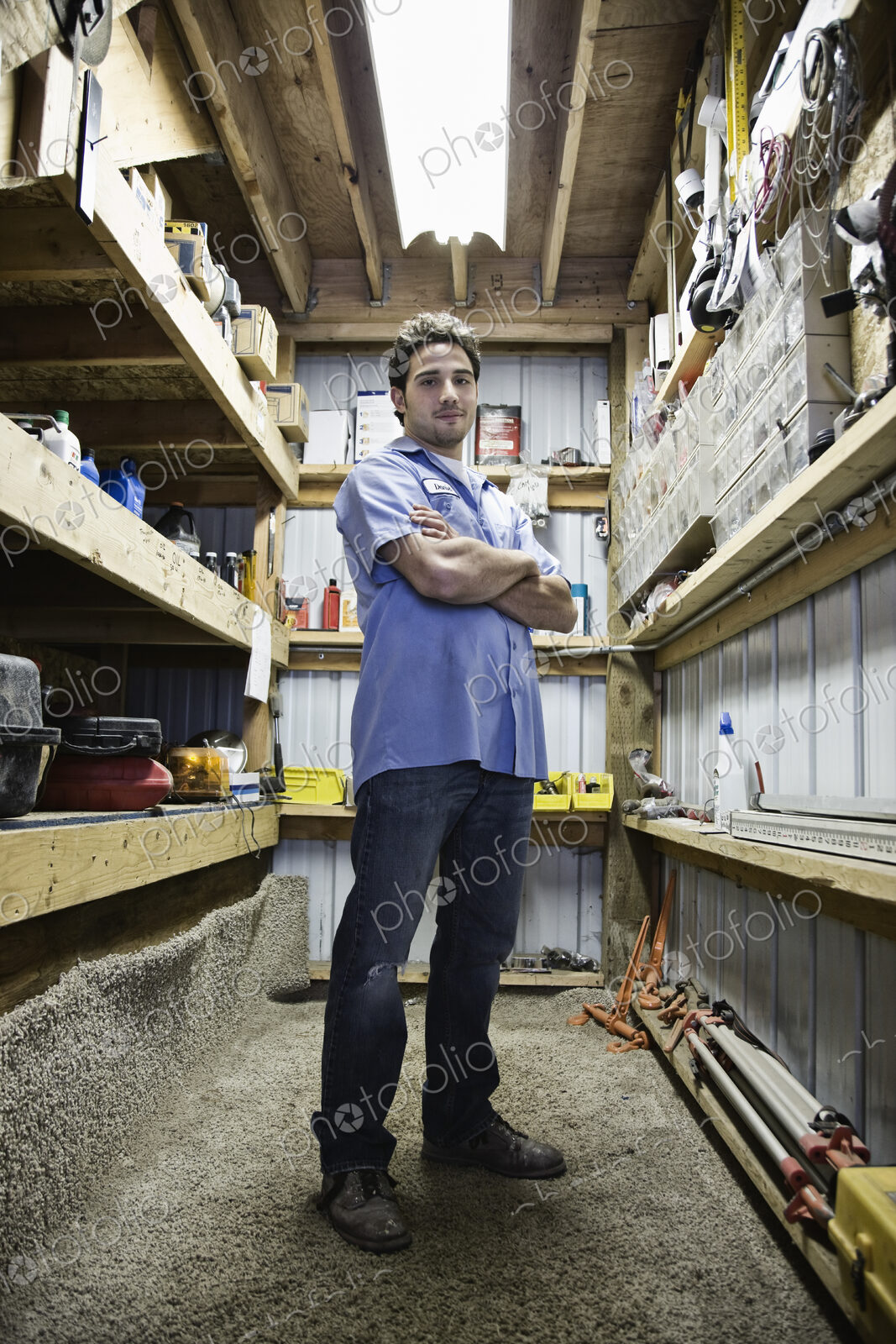 Caucasian man employee standing in the parts department of a landscape company.
