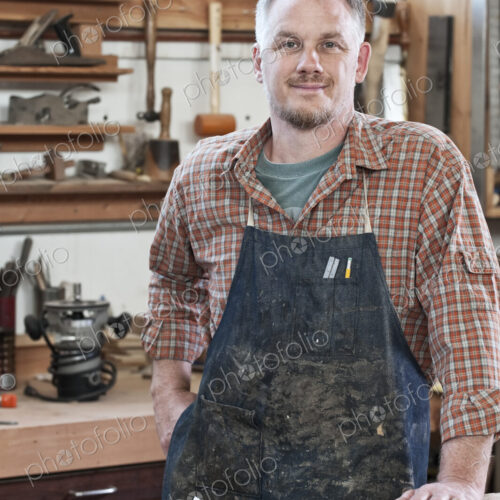 Caucasian man factory worker at a work station in a woodworking factory.