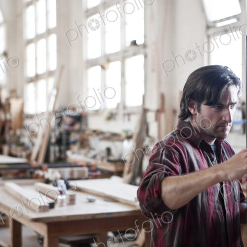 Caucasian man factory worker checking square measurements on a wooden part in a…