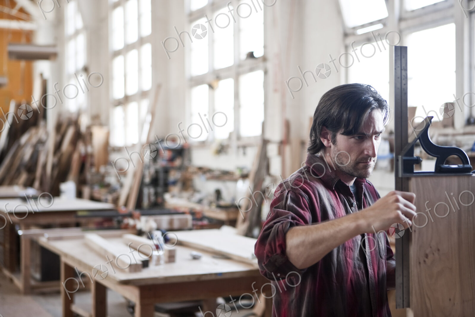 Caucasian man factory worker checking square measurements on a wooden part in a…