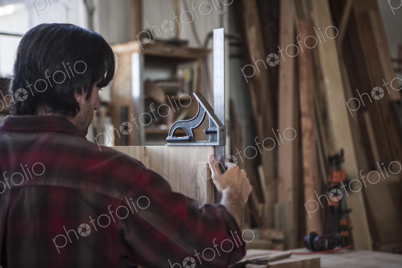 Caucasian man factory worker checking square measurements on a wooden part in a…