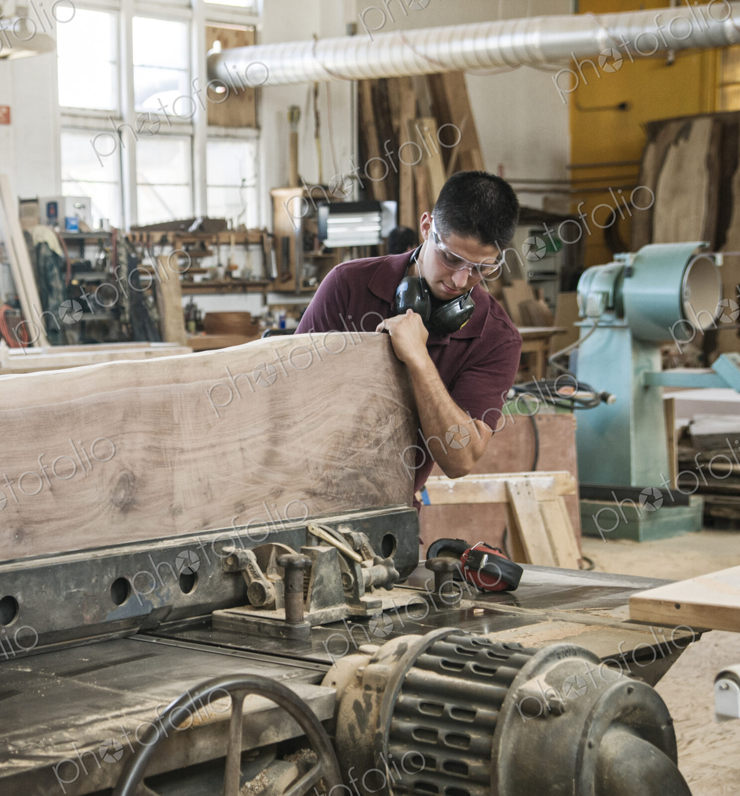 Caucasian man factory worker cutting a large wooden slab in a woodworking factory.