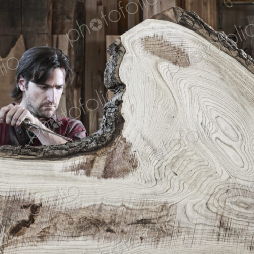 Caucasian man factory worker working on a cut piece from a section of a reclaimed…