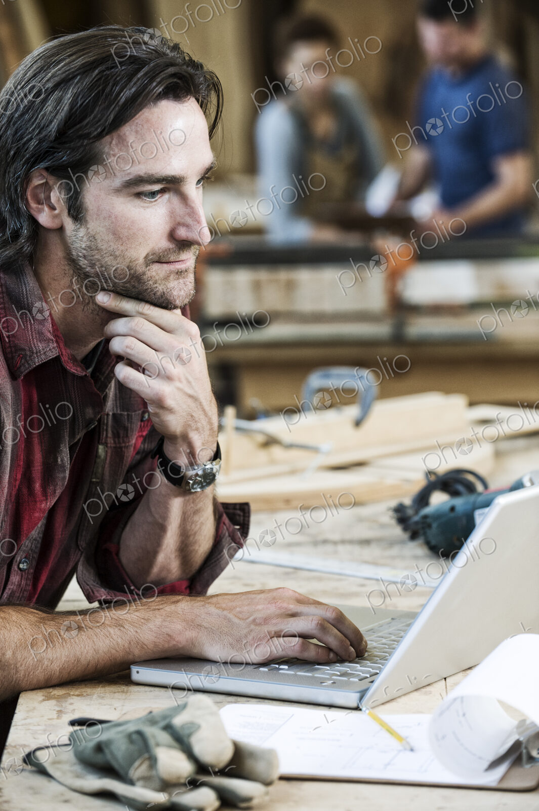 Caucasian man factory worker working on a lap top computer at a work station in a…
