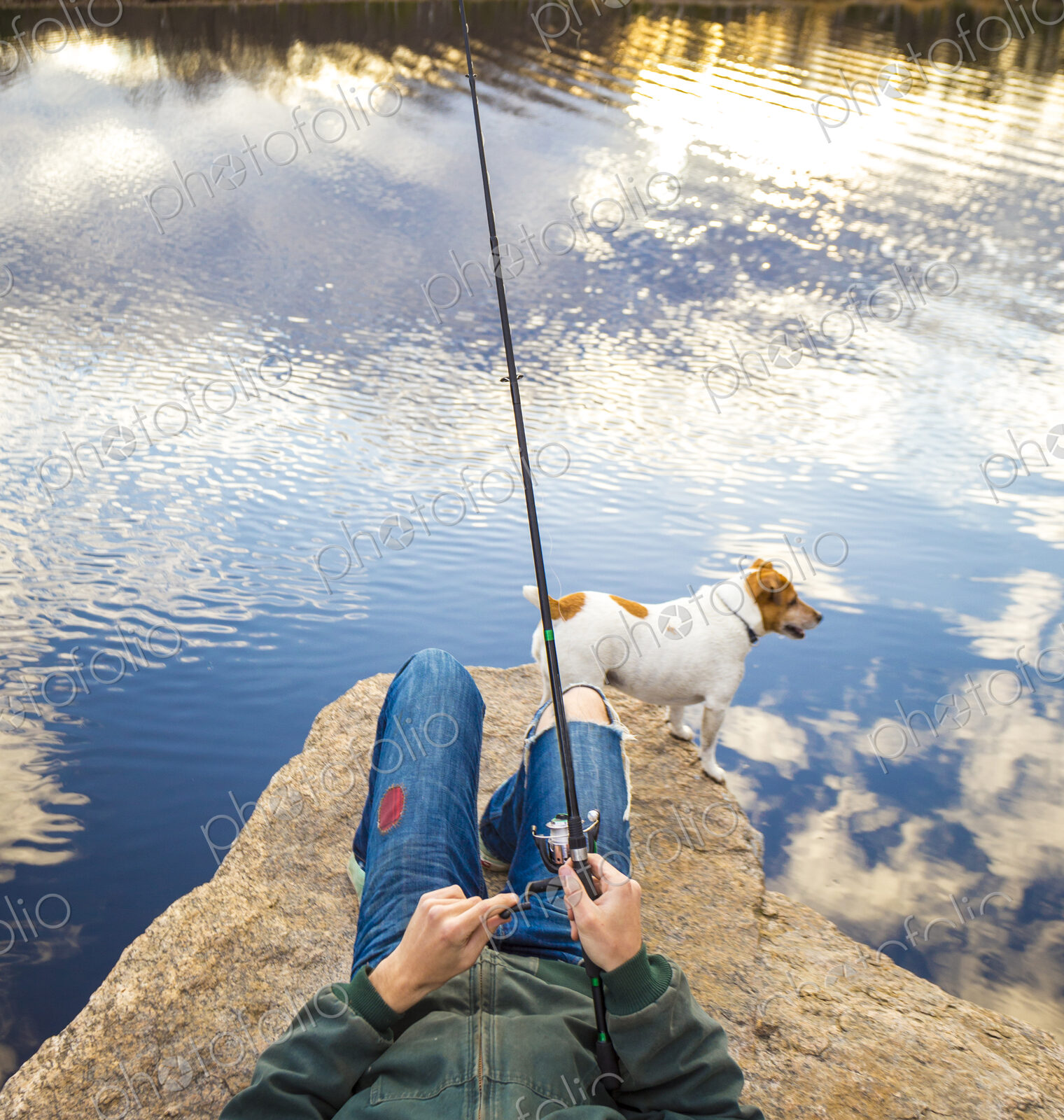 Caucasian man fishing with dog in remote lake