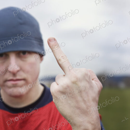 Caucasian man giving the viewer the finger as an obscene gesture. Caucasian man giving the viewer the finger as an obscene gesture.