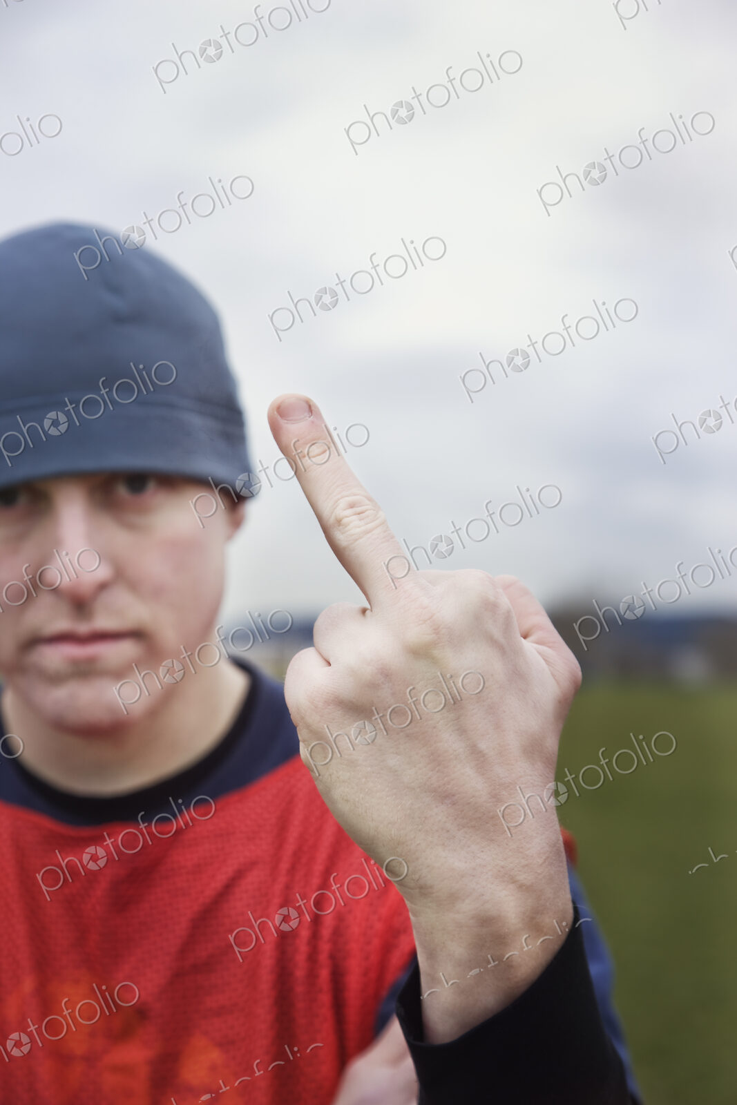 Caucasian man giving the viewer the finger as an obscene gesture.