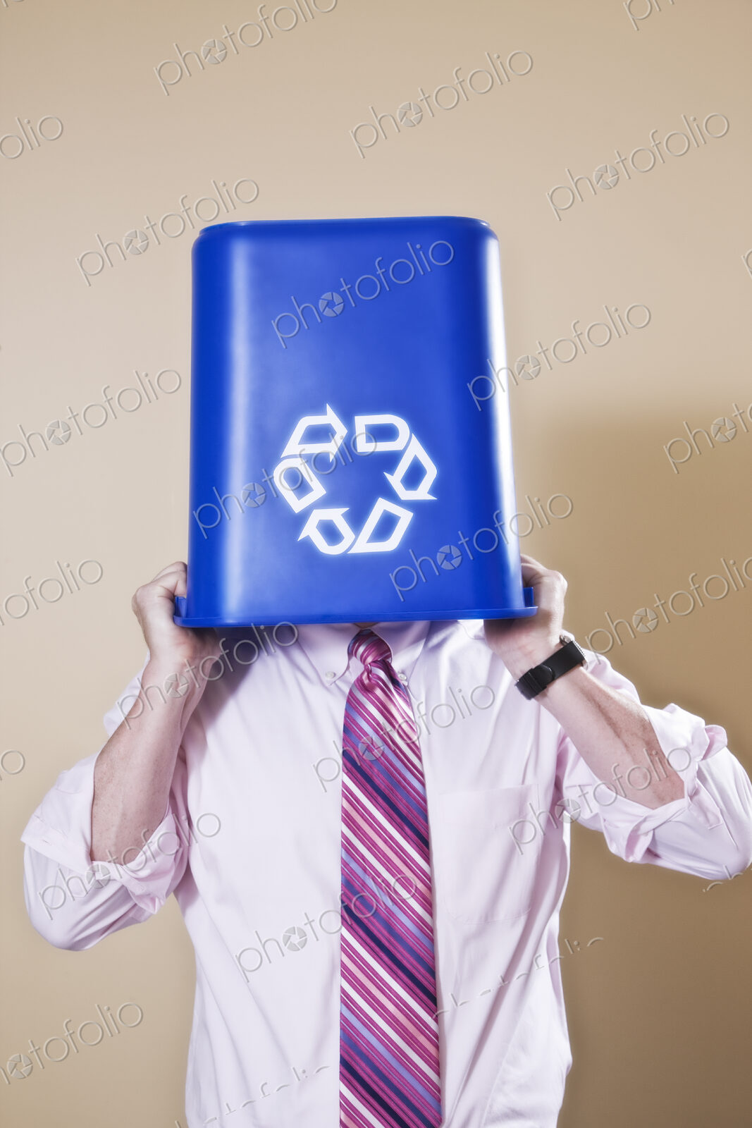 Caucasian man in shirt and tie holding a recycle waste bin.