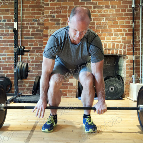 Caucasian man lifting weights in gymnasium