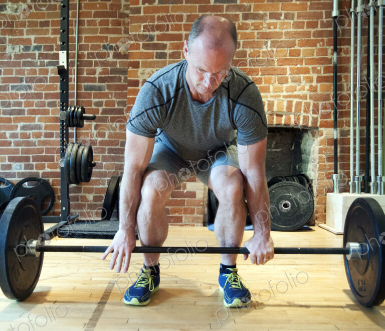 Caucasian man lifting weights in gymnasium