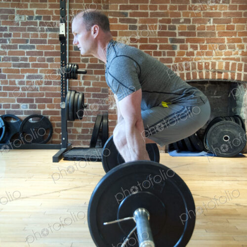 Caucasian man lifting weights in gymnasium