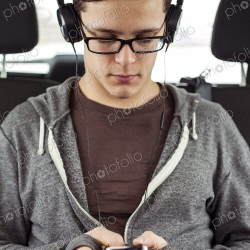 Caucasian man listening to mp3 player in car