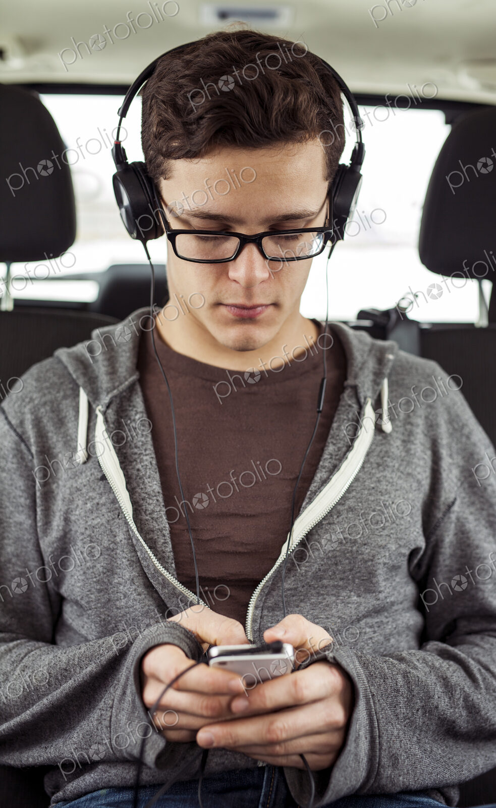 Caucasian man listening to mp3 player in car