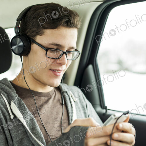 Caucasian man listening to mp3 player in car