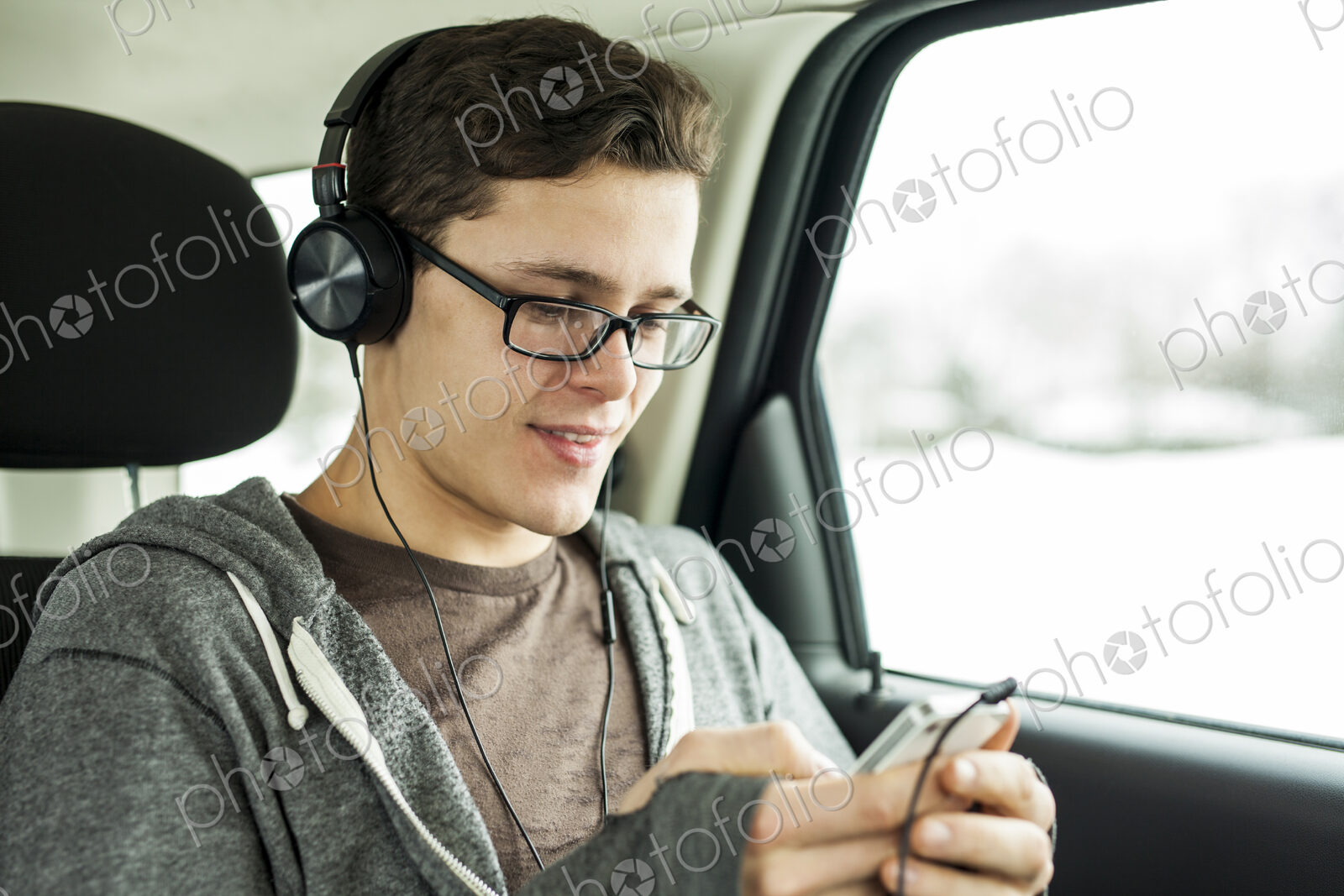 Caucasian man listening to mp3 player in car