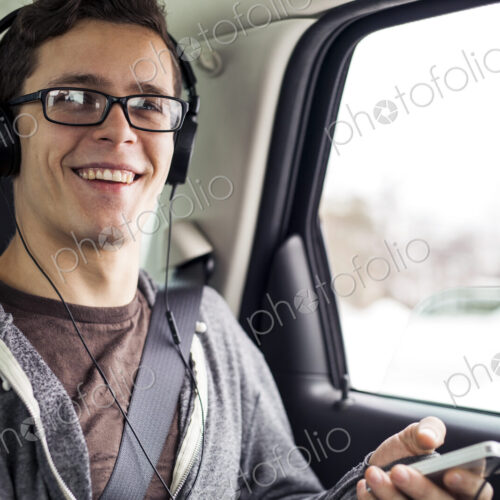 Caucasian man listening to mp3 player in car