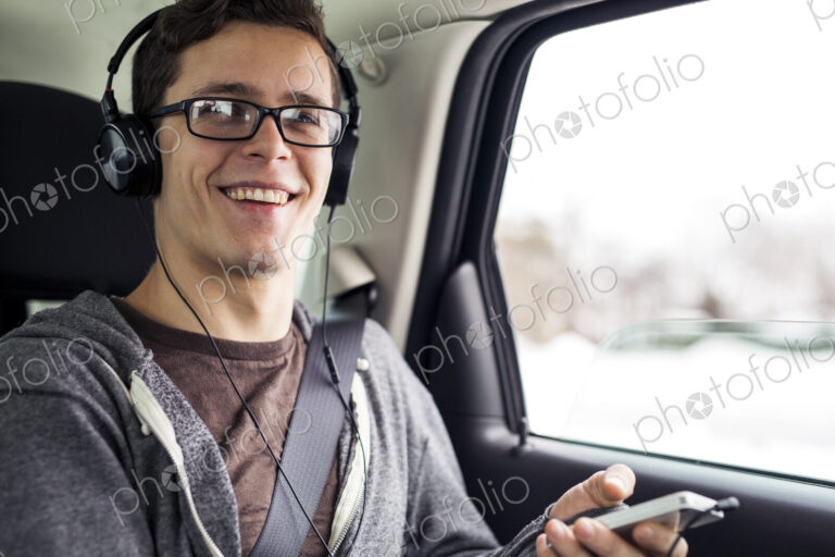 Caucasian man listening to mp3 player in car