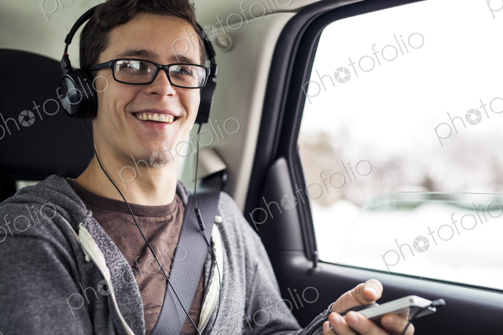 Caucasian man listening to mp3 player in car
