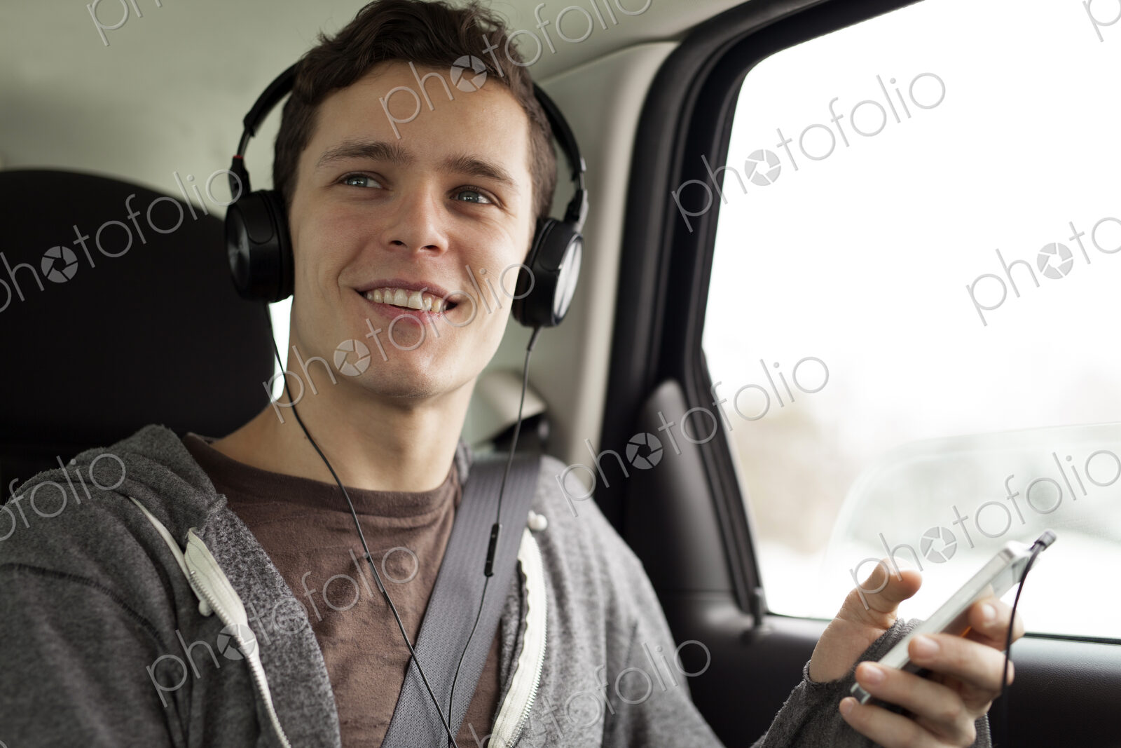 Caucasian man listening to mp3 player in car