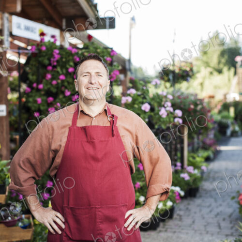 Caucasian man nursery owner standing with plants for sale at the nursery.