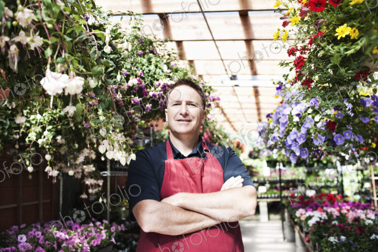 Caucasian man nursery owner standing with plants for sale at the nursery.