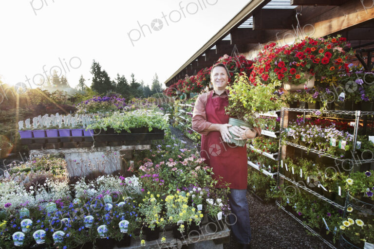 Caucasian man nursery owner standing with plants for sale at the nursery.