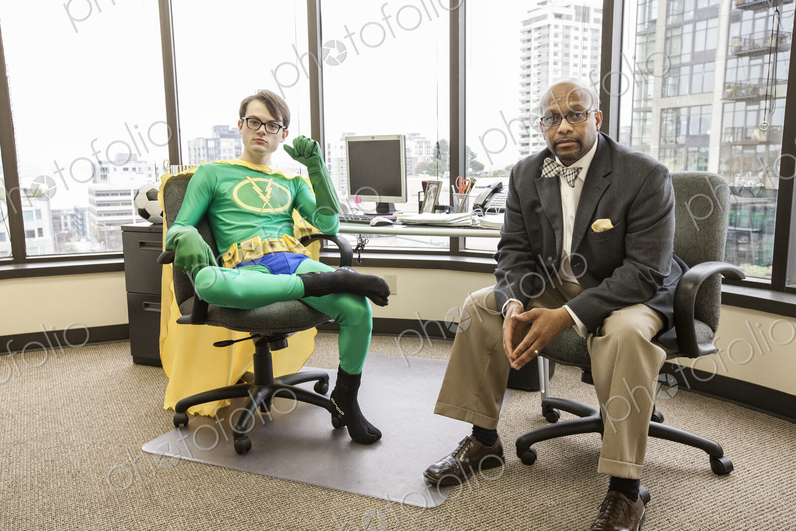 Caucasian man office super hero with his advisor, a black business man.