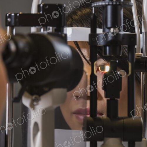 Caucasian man ophthalmologist using a slit lamp tonometer on a patient's eye. Caucasian man ophthalmologist using a slit lamp tonometer on a patient's eye.