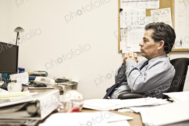 Caucasian man problem solving at his office desk.