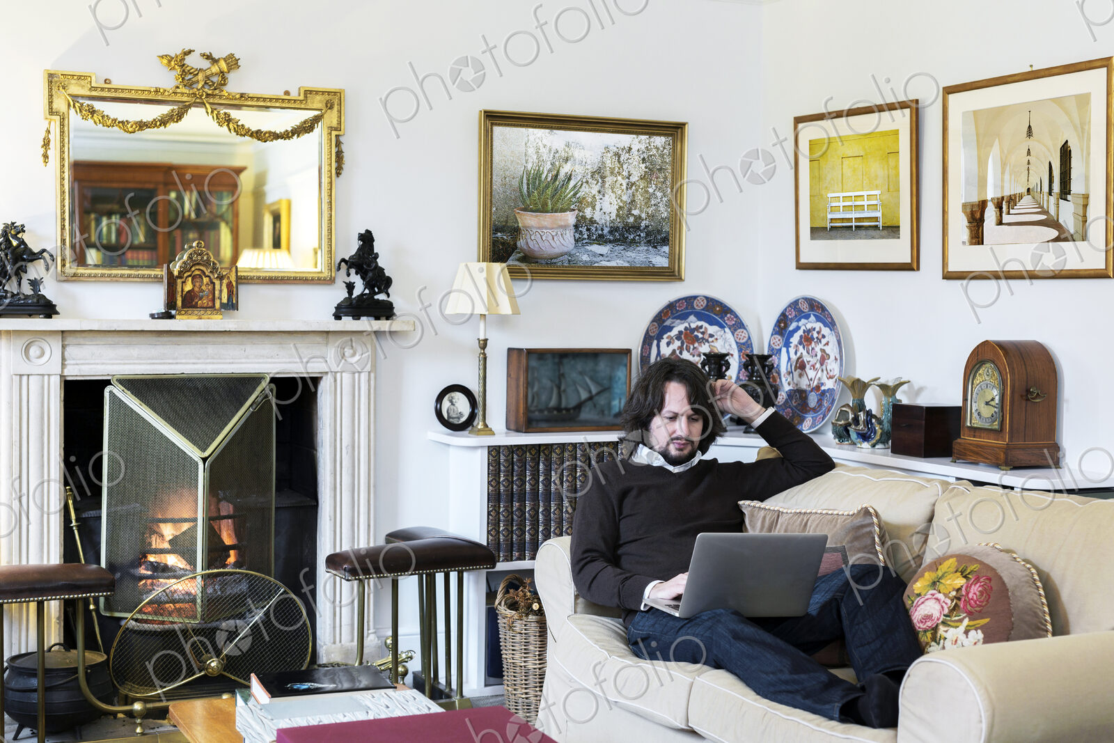 Caucasian man sitting on sofa using laptop