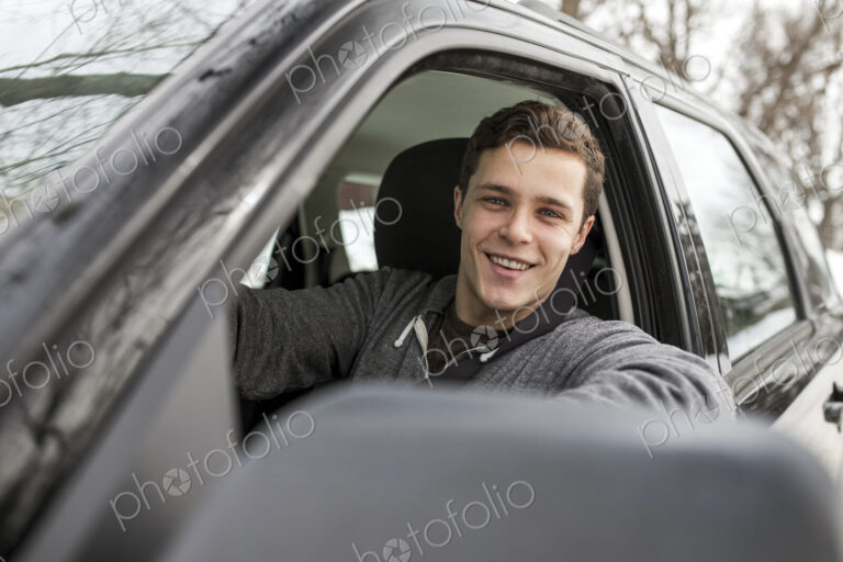 Caucasian man smiling in car window