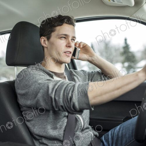 Caucasian man talking on cell phone and driving car