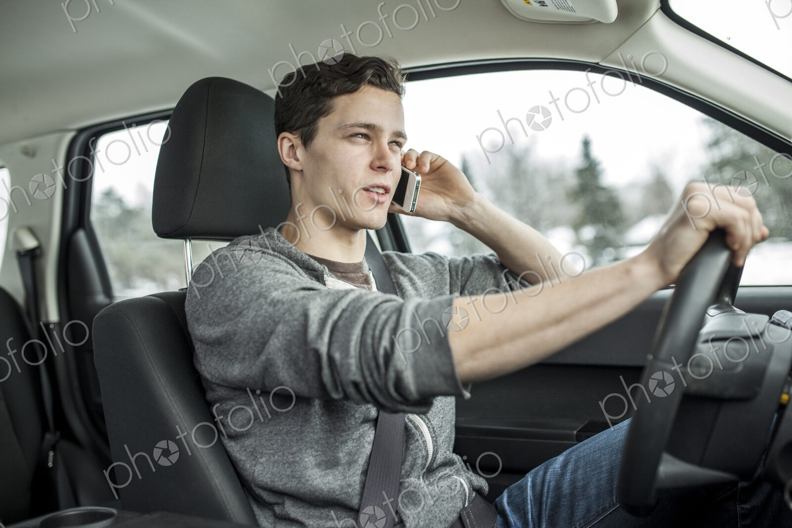 Caucasian man talking on cell phone and driving car