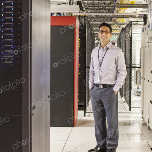 Caucasian man technician working with computer servers in a computer server farm.