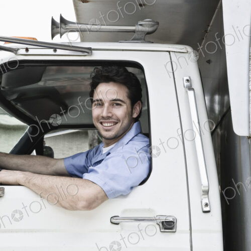 Caucasian man truck driver in company truck window.