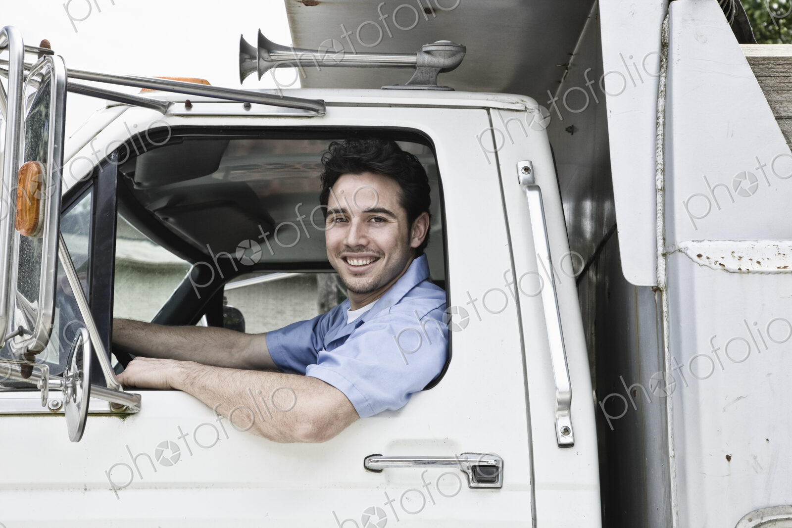 Caucasian man truck driver in company truck window.