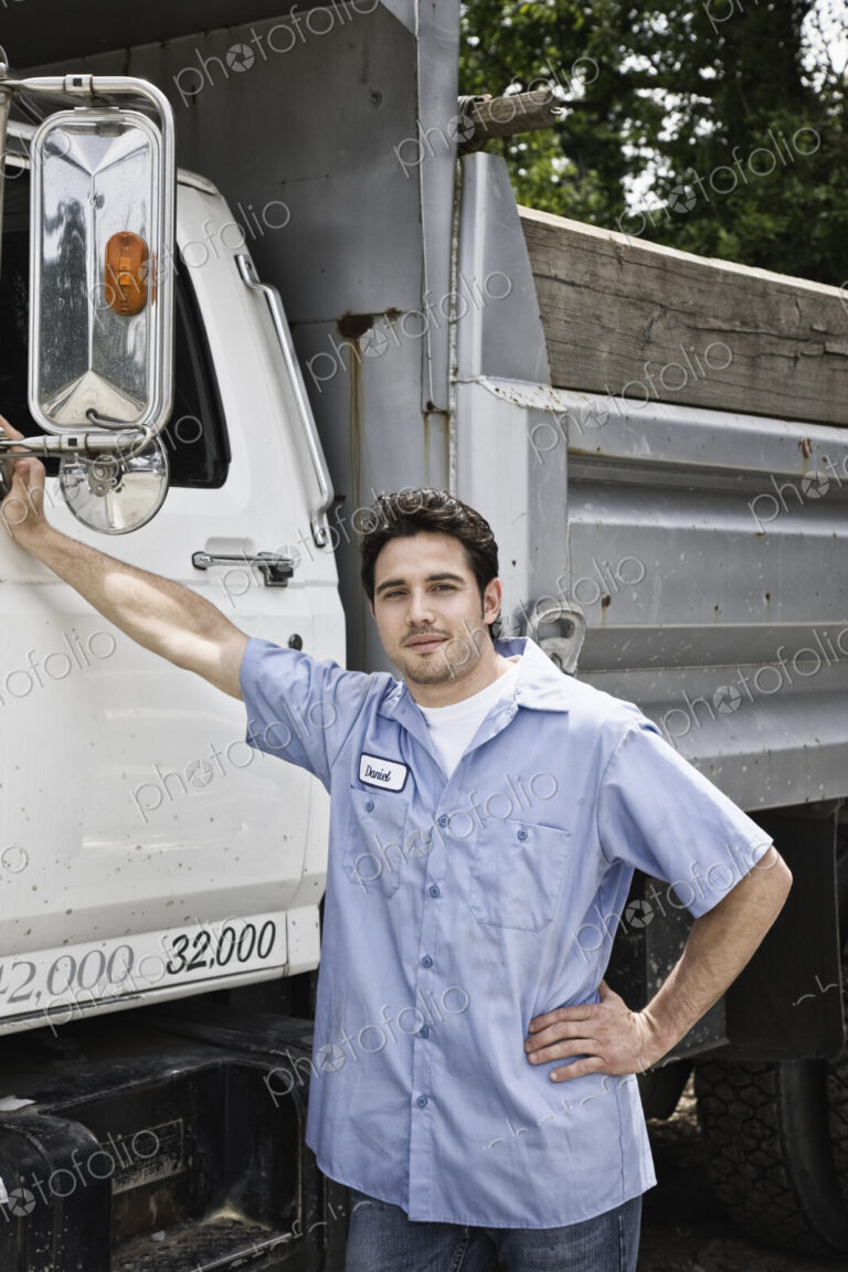 Caucasian man truck driver next to company truck.