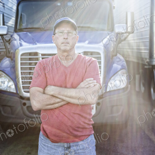 Caucasian man truck driver with his truck parked in a lot at a truck stop. Caucasian man truck driver with his truck parked in a lot at a truck stop.