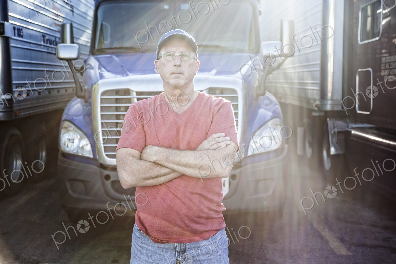 Caucasian man truck driver with his truck parked in a lot at a truck stop.