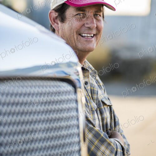 Caucasian man truck driver with his truck parked in a lot at a truck stop. Caucasian man truck driver with his truck parked in a lot at a truck stop.