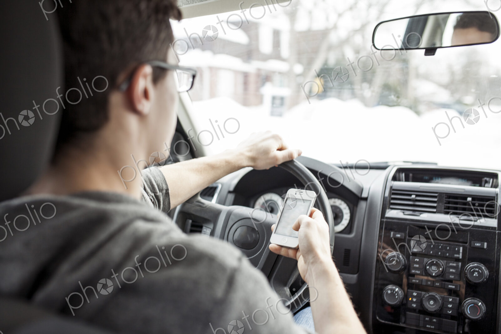Caucasian man using cell phone and driving car