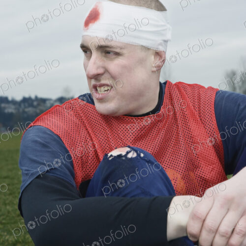 Caucasian man with a bandaged head, a head injury, sitting on the ground. Caucasian man with a bandaged head, a head injury, sitting on the ground.
