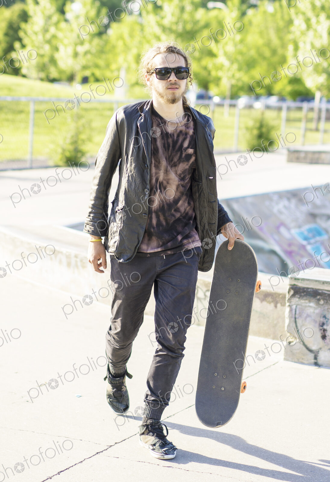 Caucasian man with beard carrying skateboard