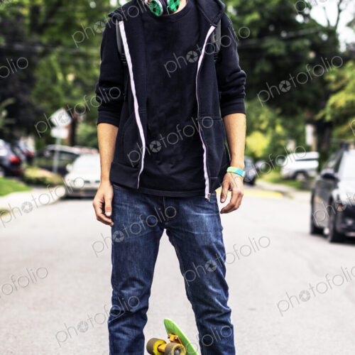 Caucasian man with headphones standing on skateboard Caucasian man with headphones standing on skateboard