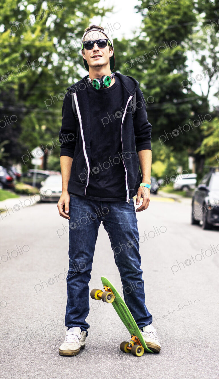 Caucasian man with headphones standing on skateboard