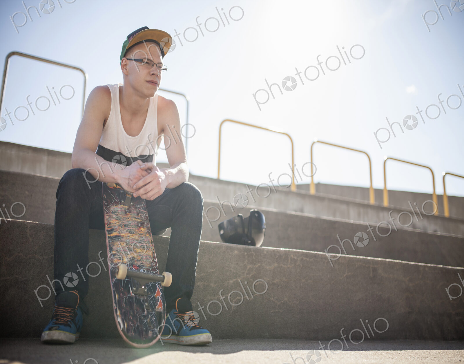 Caucasian man with skateboard sitting on steps