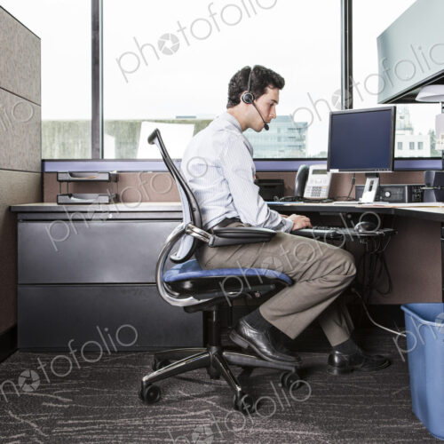 Caucasian man working in an office cubicle.